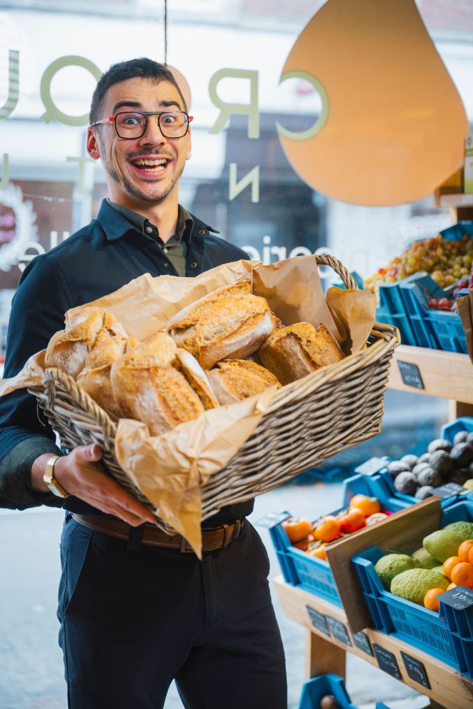 Le gérant de Croquez Nature avec une corbeille de pains artisanaux, à Ath